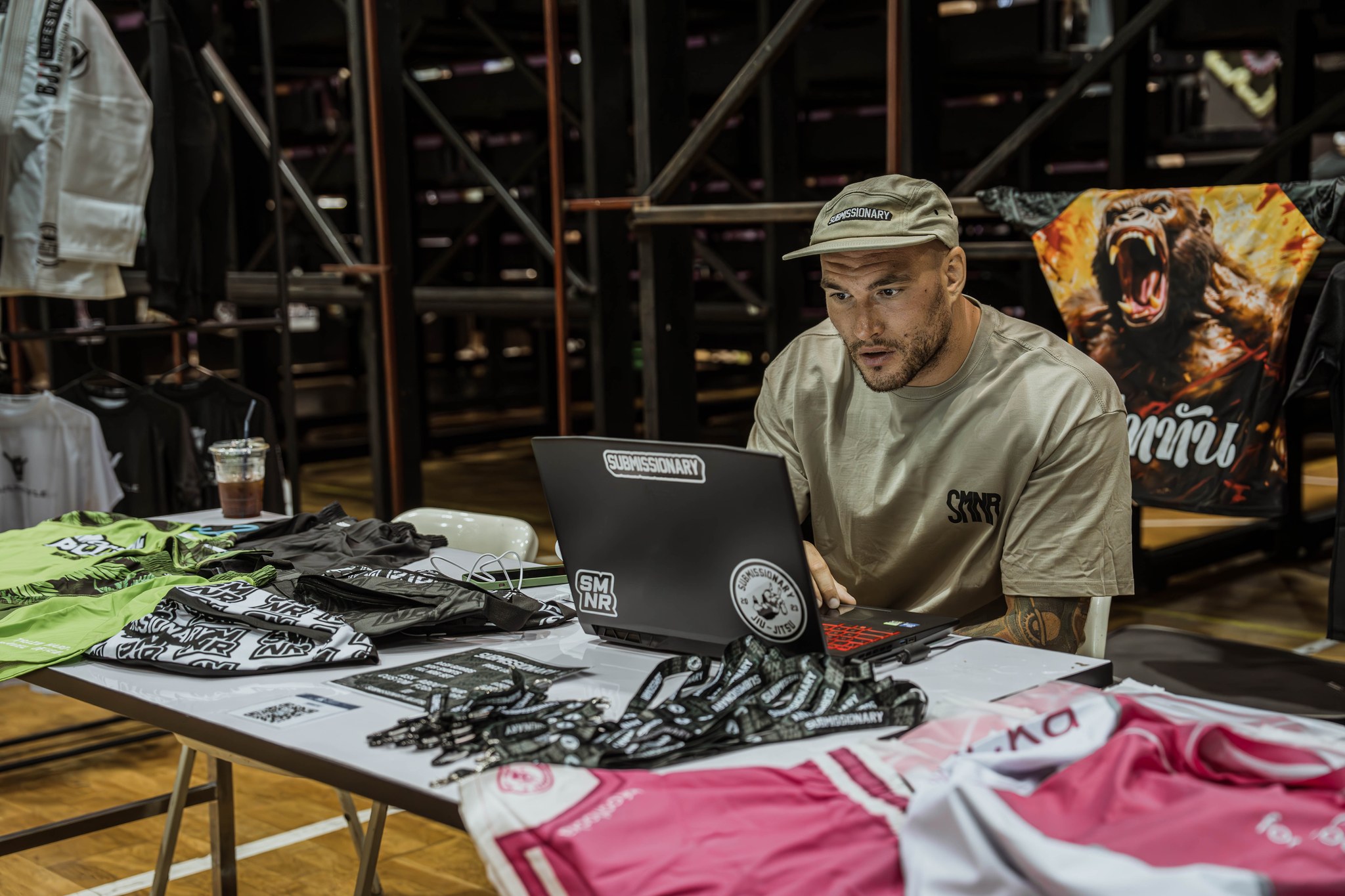 Submissionary team member behind an event stand with branded kit