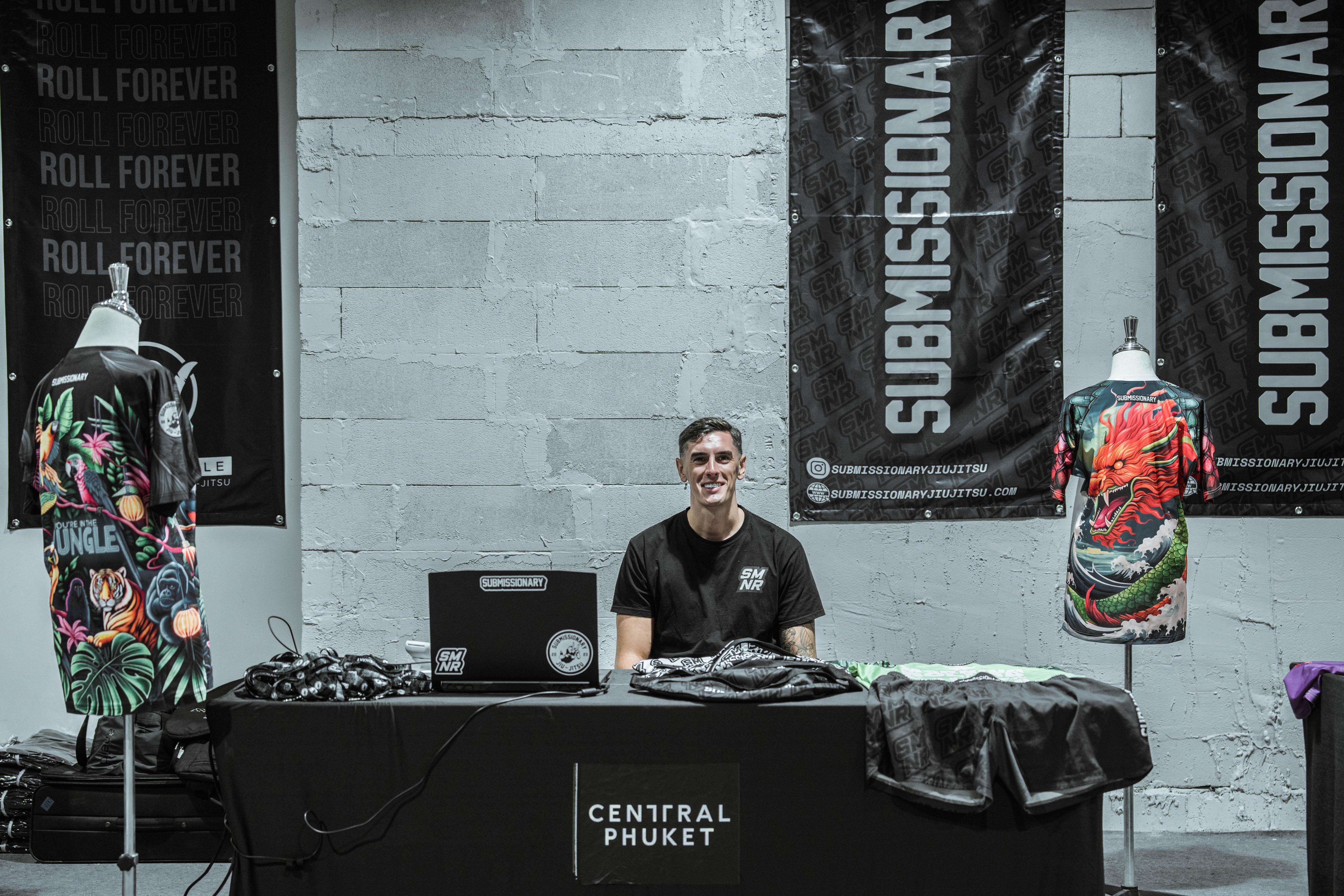 Submissionary event stand with branded banners and rashguards on display